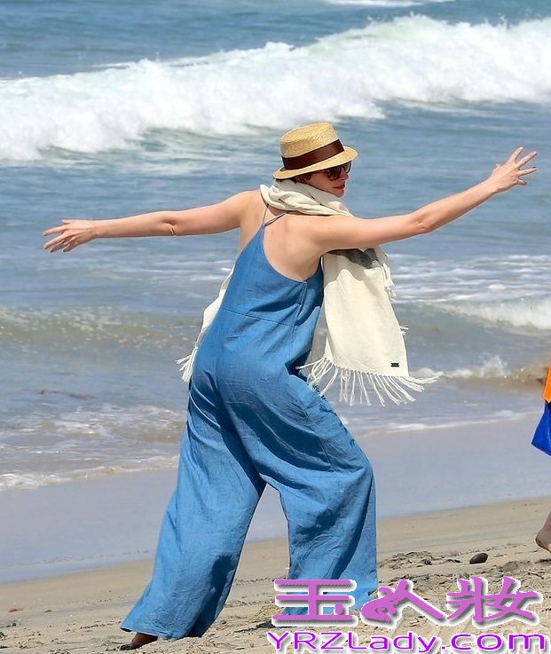 据悉，超爱大海的安妮-海瑟薇近日出现在某海滩戏水，当然安妮-海瑟薇穿着一席天空蓝连衣背带裤，一条米色流苏围巾，尽显居家休闲时尚。虽然是安妮-海瑟薇是带着墨镜，但也能看得出心情很好。