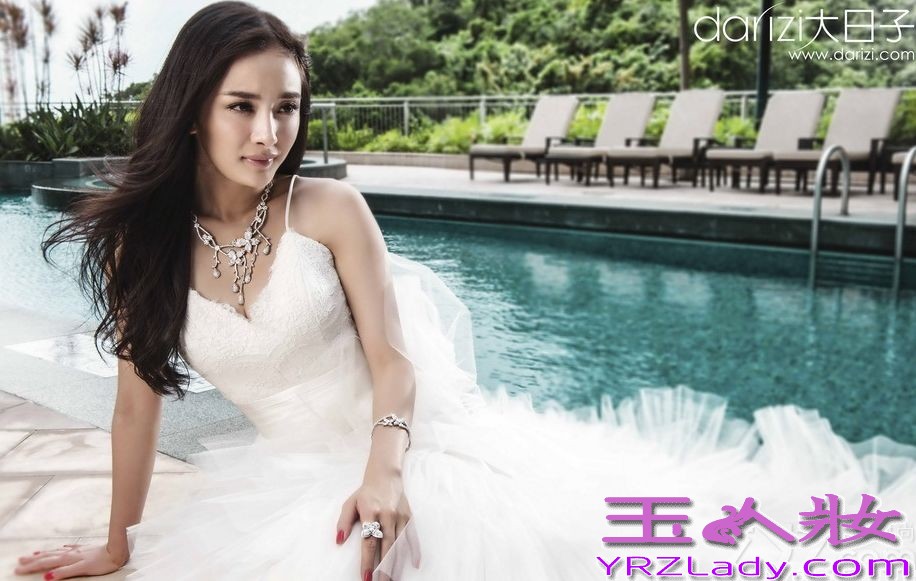 近日，事业爱情双赢的小花旦杨幂为香港著名新娘杂志拍摄了一组优雅婚纱礼服写真。图片中杨幂身穿甜美礼服短裙泳池边快乐嬉水。一袭纯白优雅婚纱与青青草地相互呼应，脸上洋溢着幸福的笑容。紫色抹胸礼服衬托出白皙的美肌，性感身材若隐若现，甜美优雅也不失小清新感。