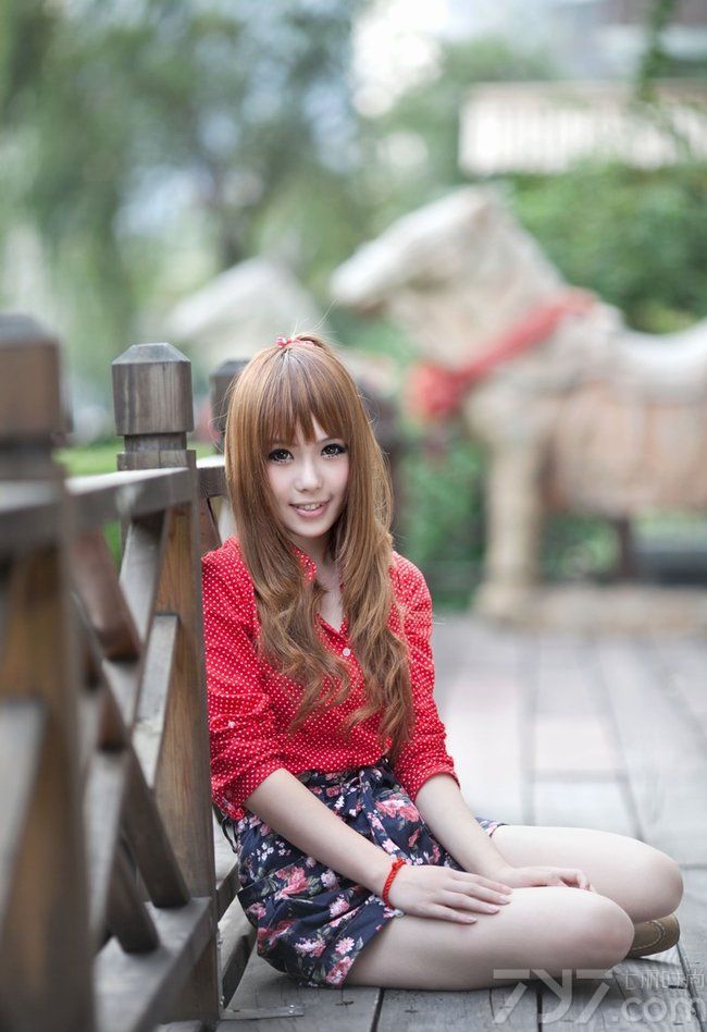 早晨甜美小女人慵懒十足，可爱脸庞惹人爱，美丽芳华似水，长卷发小女生很是靓丽，身穿红色波点上衣配上碎花包裙，显瘦显高。