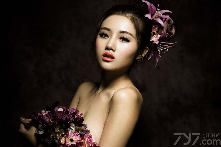 在暗色的光线中拍摄出来的图片，透露着少于的复古感，娇嫩的红唇美美折射出光晕，诱惑难挡。手中的鲜花遮挡了MM诱人的美胸，性感的锁骨让你忍不住多看几眼，下面一起来看看性感美女全裸出镜图片，曼妙身姿被鲜花婚纱簇拥。