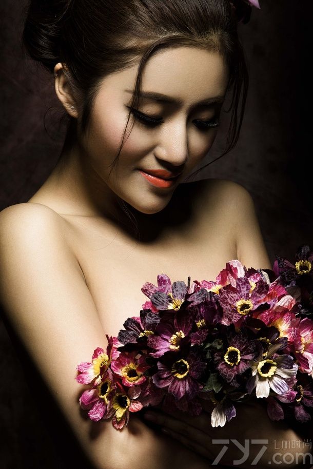 在暗色的光线中拍摄出来的图片，透露着少于的复古感，娇嫩的红唇美美折射出光晕，诱惑难挡。手中的鲜花遮挡了MM诱人的美胸，性感的锁骨让你忍不住多看几眼，下面一起来看看性感美女全裸出镜图片，曼妙身姿被鲜花婚纱簇拥。