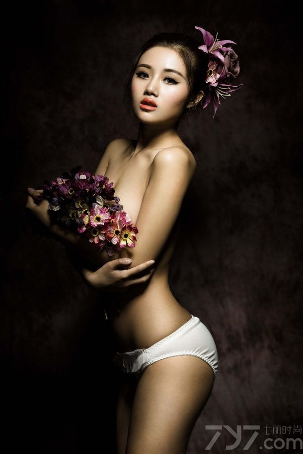 在暗色的光线中拍摄出来的图片，透露着少于的复古感，娇嫩的红唇美美折射出光晕，诱惑难挡。手中的鲜花遮挡了MM诱人的美胸，性感的锁骨让你忍不住多看几眼，下面一起来看看性感美女全裸出镜图片，曼妙身姿被鲜花婚纱簇拥。