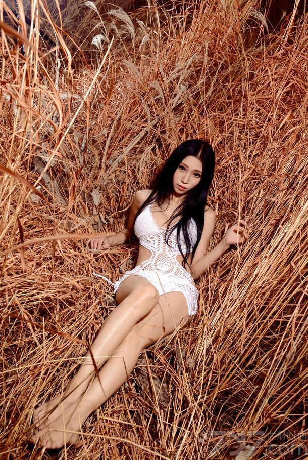大片略显枯黄的芦苇丛中洋溢着秋季的韵味，长腿美女穿着白色的网洞透视装，尽显出苗条身材，S型曲线让男人大喷鼻血，健康的肤色尤其诱惑。轻轻靠着芦荟丛中，乖巧无辜的眼神惹人心疼。下面一起来看看长腿美女性感透视装图片，深秋芦苇别样诱惑。