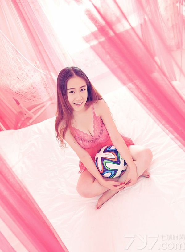 粉红色的帘子垂落在床边，薄纱随着MM的搔首弄姿而舞动起来，轻盈之感配合着暧昧的气氛。在她怀里的足球受宠若惊，俏皮和美女一同嬉戏着，阳光晒在软软的床上，女孩心中不安分的因子依然在跳动。下面一起来看看美女手捧足球床上性感写真图片，秀色可餐迷晕众男神。