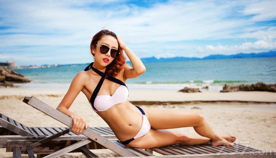 大海的辽阔无边是每个人都向往的，皎洁无比的蔚蓝海面本来就令人向往，要是还有美女做陪，就更是诱人了。下面分享一组超美的户外海边美女模特写真，身穿交叉挂脖比基尼，曲线身姿展示无疑，散发致使诱惑。